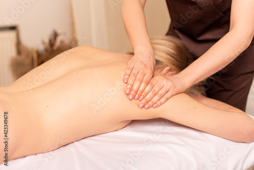 Close up photo of deep tissue massage. Masseuse doing shoulder and back massage