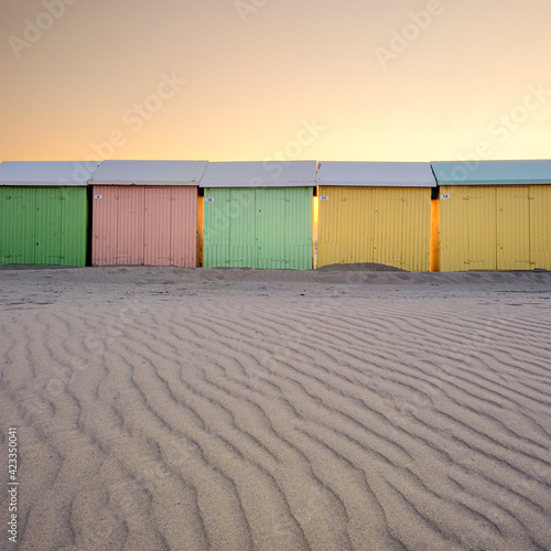 Colorful beach huts at sunset