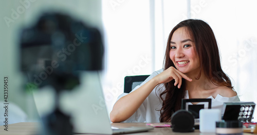 Young and beautiful Asian girl talking to camera with smile face and happy during broadcast video recording about cosmetics content and review. Online selling and marketing concept.