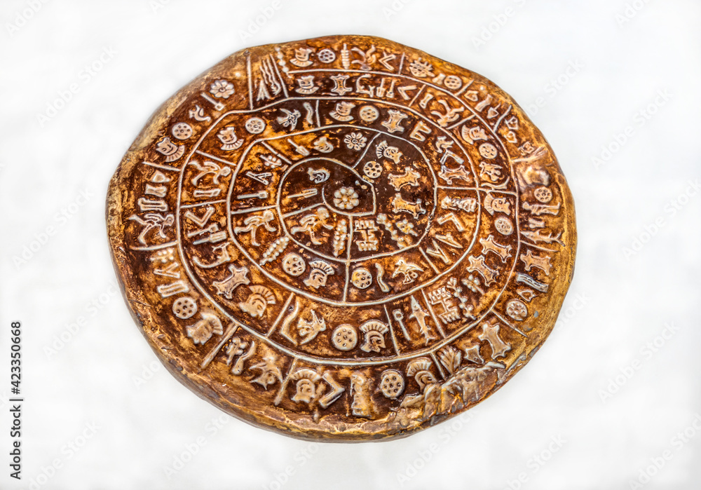 Clay copy of the Phaistos disc isolated on white background
