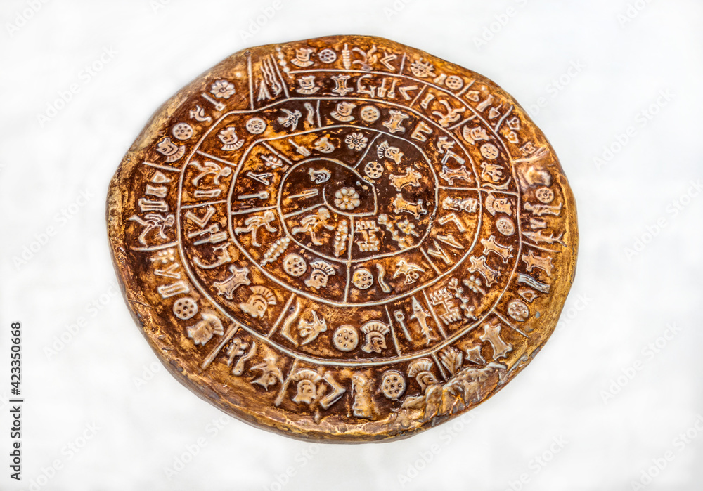 Clay copy of the Phaistos disc isolated on white background Clay copy of the Phaistos disc isolated on white background