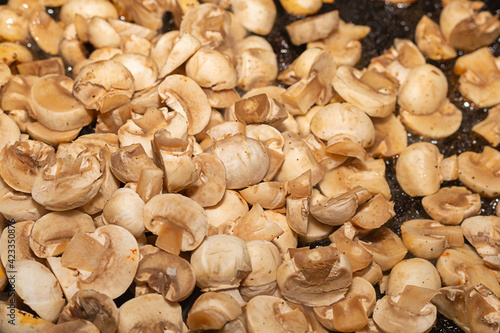 fresh mini mushrooms champignons chopped fried in a pan