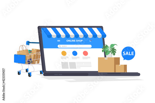 Shopping cart and laptop computer with products isolated on white background, shop online concept.