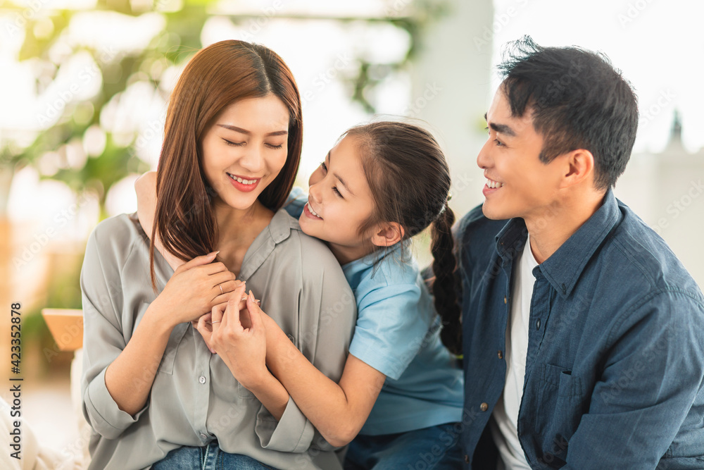 Happy family smiling and hugging on the couch at home