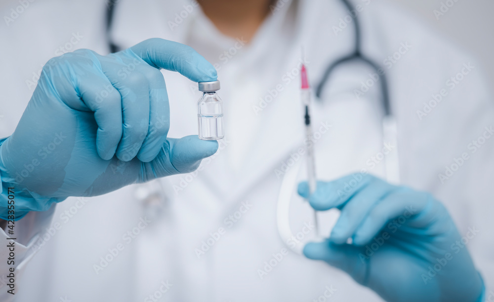 Doctor or scientist with a stethoscope holding COVID-19 vaccine, measles, coronavirus vaccine shot for diseases outbreak vaccination, vaccine Concept fight against virus covid-19 corona virus Doctor or scientist with a stethoscope holding COVID-19 vaccine, measles, coronavirus vaccine shot for diseases outbreak vaccination, vaccine Concept fight against virus covid-19 corona virus