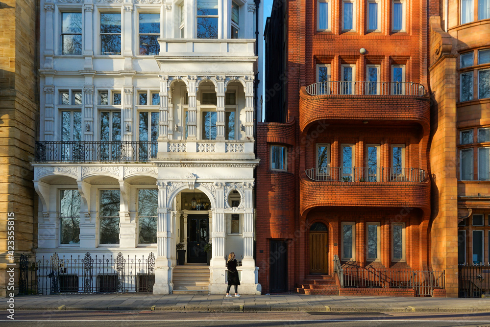 Φωτογραφία Girl walking in front of buildings on the streets of London