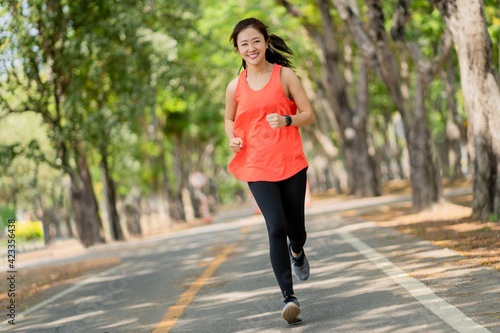 Healthy woman are running in the park in the morning. She smiled and enjoyed.