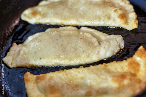traditional dish tatar cheburek with meat is fried in a pan with a golden crust