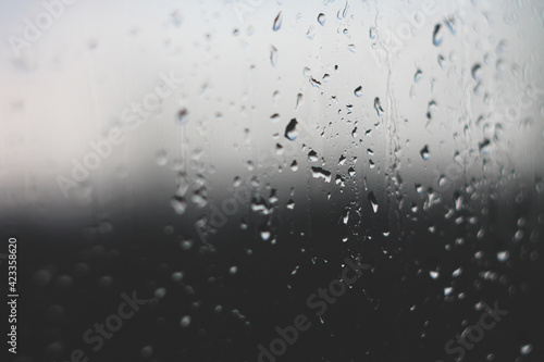 Raindrops on glass embodying sadness and grief in black and white