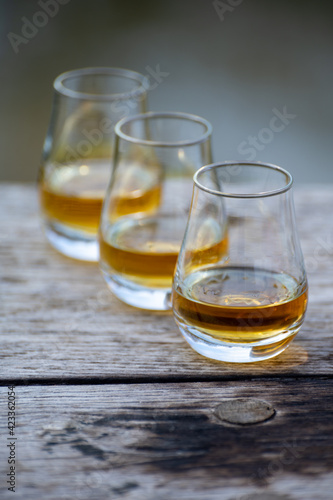 Tasting glasses of scotch whisky strong drink on old outdoor wooden table © barmalini