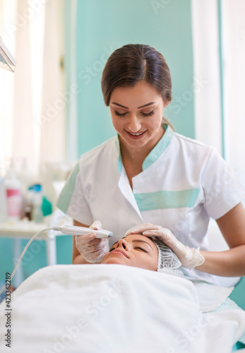 Woman in spa salon receive skin ultrasonic cleaning treatment of the face
