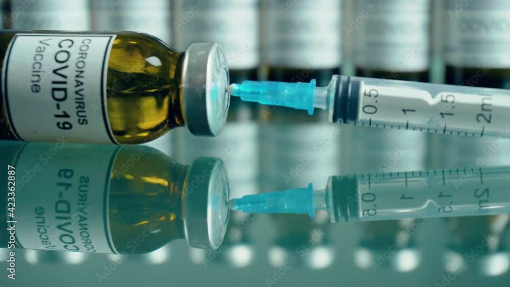 Ampoules with anti coronavirus vaccine injection and syringe in centre