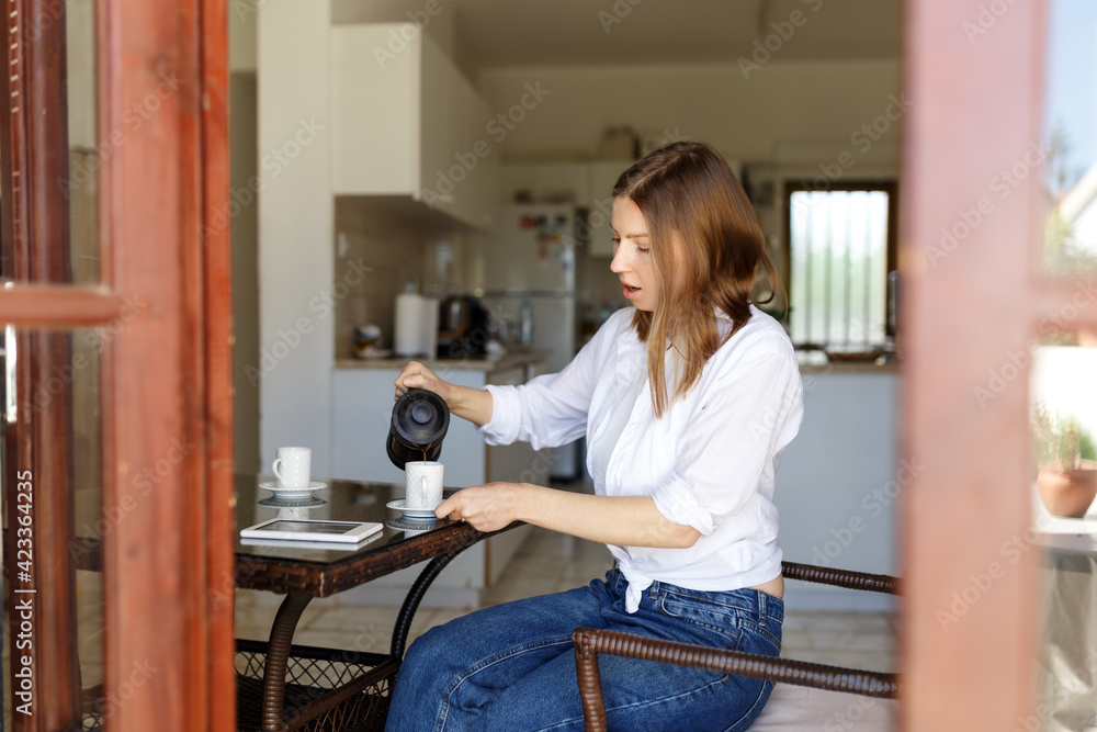 Photo of a woman on her break pouring herself a mug of hot filtered coffee from a glass pot