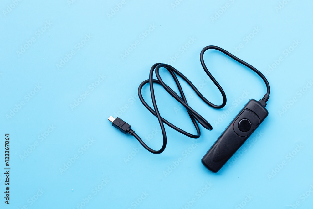 Remote control shutter switch of DSLR or mirrorless camera on blue background. Remote control shutter switch of DSLR or mirrorless camera on blue background.