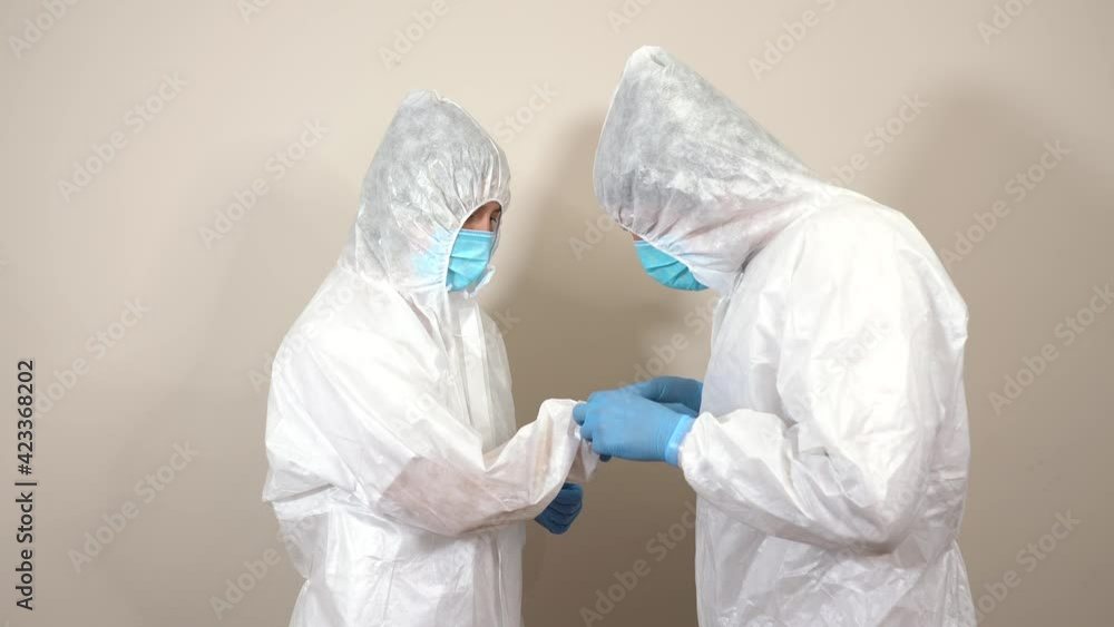 nurses at ppe helping each other remove gloves after service nurses at ppe helping each other remove gloves after service