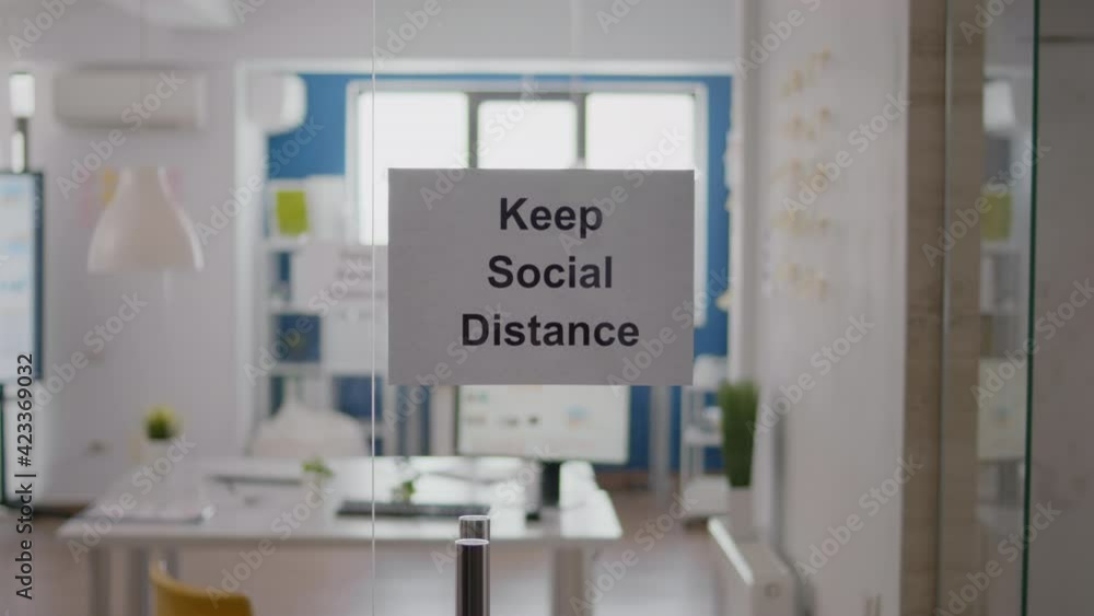 Keep Social Distance sign on glass wall in empty office during covid 19 coronavirus pandemic. Business workplace interior with nobody in it, economy crisis Keep Social Distance sign on glass wall in empty office during covid 19 coronavirus pandemic. Business workplace interior with nobody in it, economy crisis