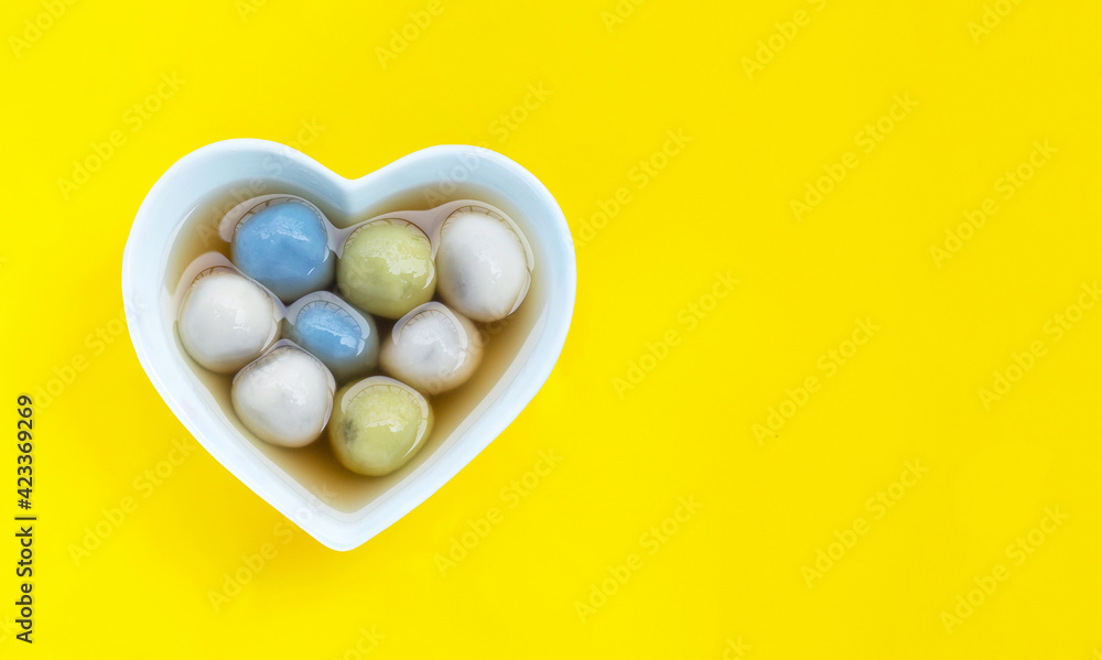 Black sesame dumpling in ginger tea recipes on yellow background. Black sesame dumpling in ginger tea recipes on yellow background.