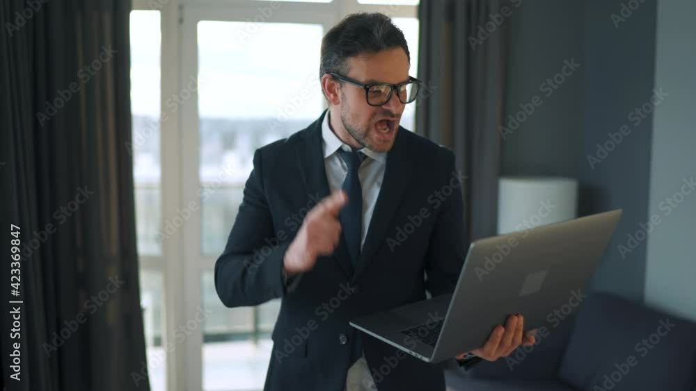 Caucasian man dressed in a jacket and underwear using laptop to make a video call from home in a modern apartment. Remote work during a pandemic Caucasian man dressed in a jacket and underwear using laptop to make a video call from home in a modern apartment. Remote work during a pandemic