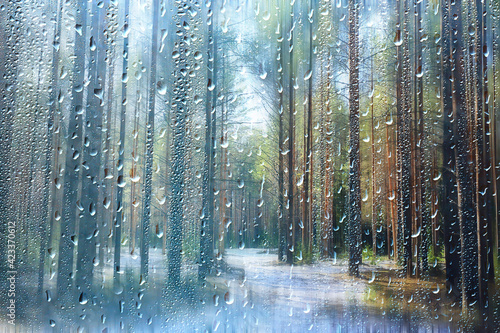 rain on glass, abstract landscape view early spring and rain behind a transparent window with raindrops