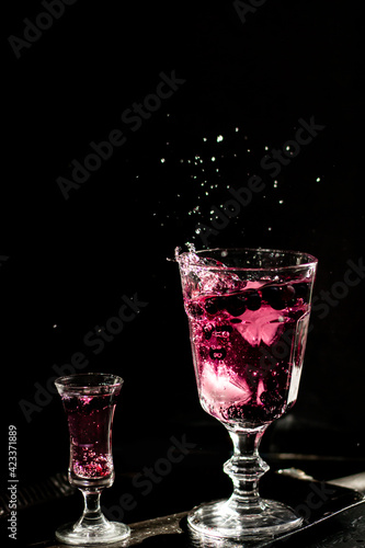 Berry drink. Dark photography. Front of the glass in focus.