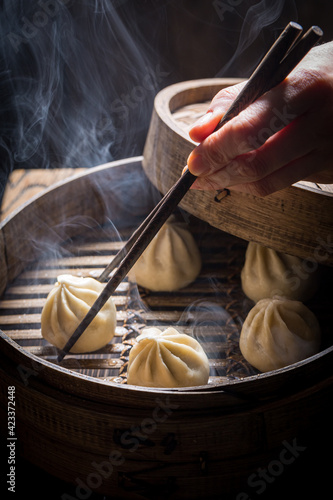 Hot chinese dumplings in wooden steamer. Old Chinese cuisine.