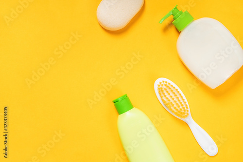 Baby accessories for bathing on bright yellow background. Care about baby soft body skin
