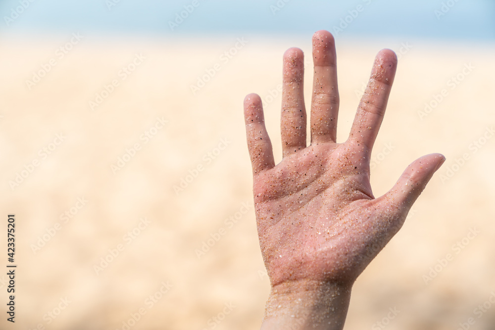 Hands stained with sand, beach and sea background. Hands stained with sand, beach and sea background.