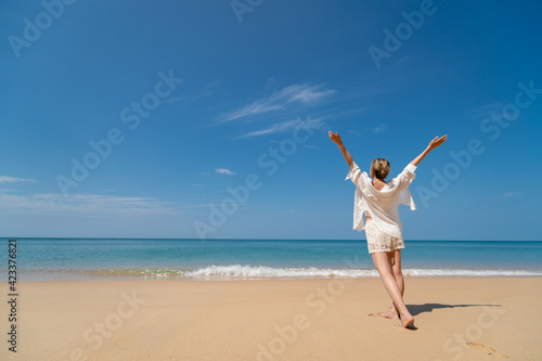 Happy young woman enjoying freedom with open hands on sea.