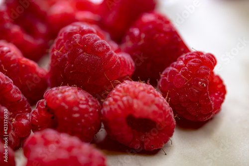still life with raspberries on a white patterned background