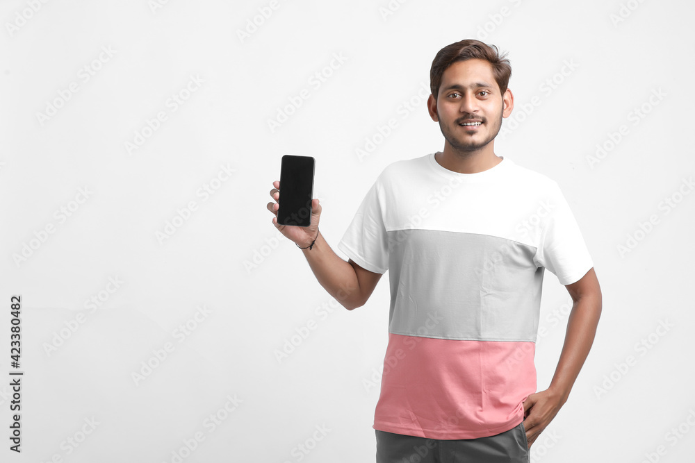 Young indian college student wearing t shirt and showing smartphone Screen Young indian college student wearing t shirt and showing smartphone Screen