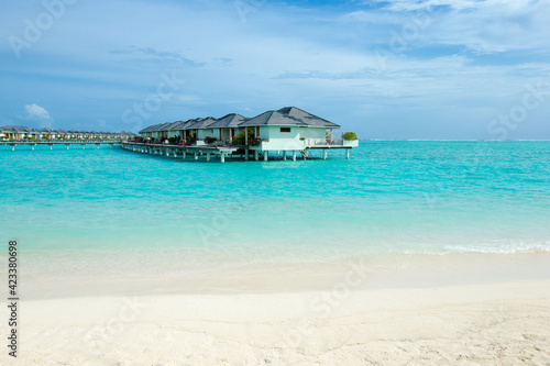 Beautiful tropical Maldives island with beach. Sea with water bungalows