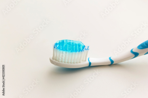 A brush for brushing your teeth with blue toothpaste.