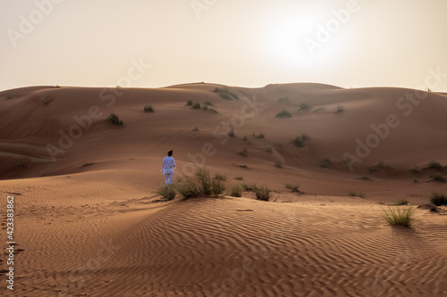 Woman walking and exploring the desert dunes © Sergio