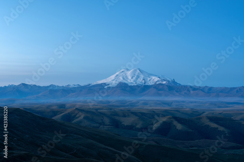 Late blue hour view of Mount Elbrus from Bermamyt plateau. Karachay-Cherkessia, Caucasus, Russia.