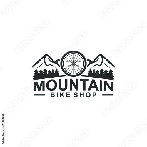 mountain bike logo design template - mountain and pine trees with bicycle wheel
