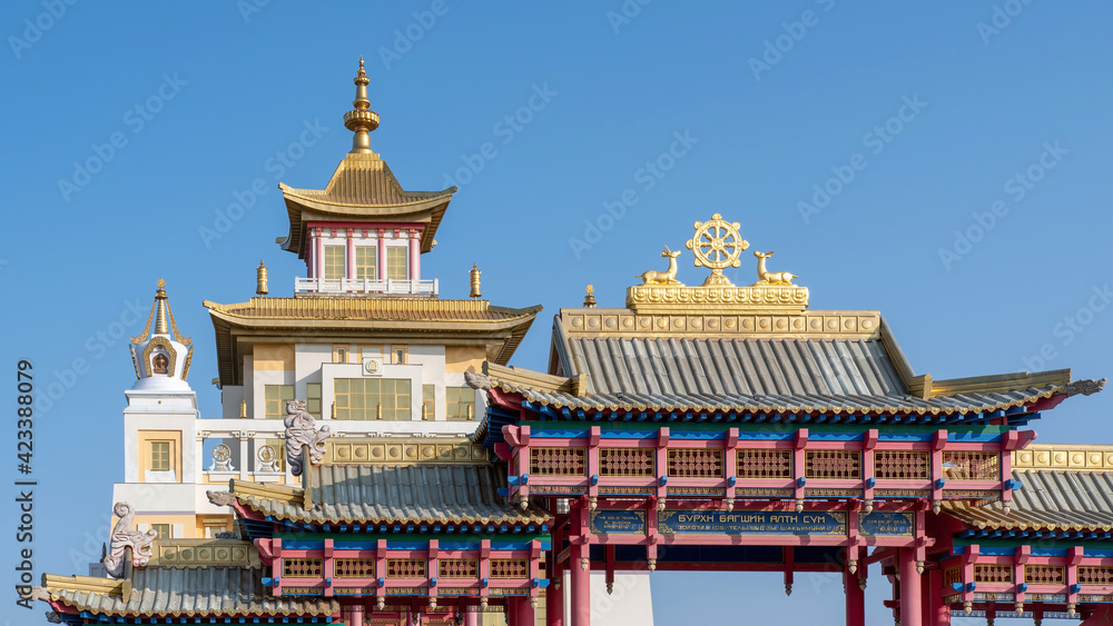 View of Golden Temple of Buddha Shakyamuni and the main gates on sunny summer day. Elista, Kalmykia, Russia. Inscription on the gates means “Golden Temple of Buddha Shakyamuni”. View of Golden Temple of Buddha Shakyamuni and the main gates on sunny summer day. Elista, Kalmykia, Russia. Inscription on the gates means “Golden Temple of Buddha Shakyamuni”.