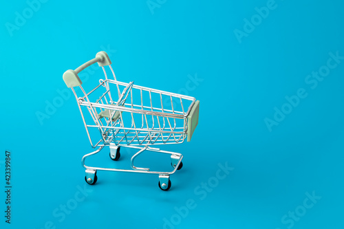 Shopping cart, supermarket trolley on blue background