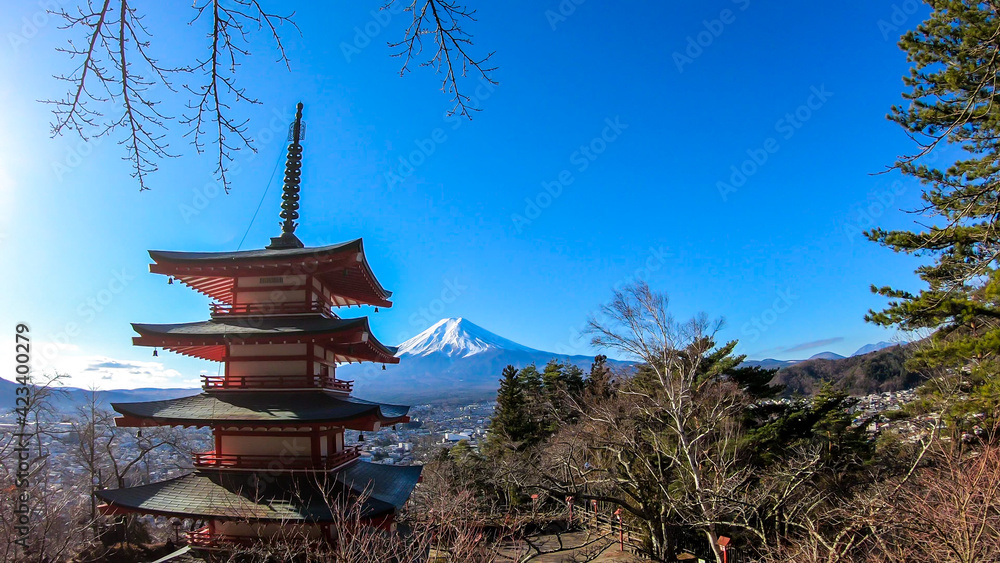 View on Chureito Pagoda and mountain of the mountains Mt Fuji, Japan, captured on a clear, sunny day in winter. Top of the volcano covered with snow. Trees aren't blossoming yet. Postcard from Japan. View on Chureito Pagoda and mountain of the mountains Mt Fuji, Japan, captured on a clear, sunny day in winter. Top of the volcano covered with snow. Trees aren't blossoming yet. Postcard from Japan.