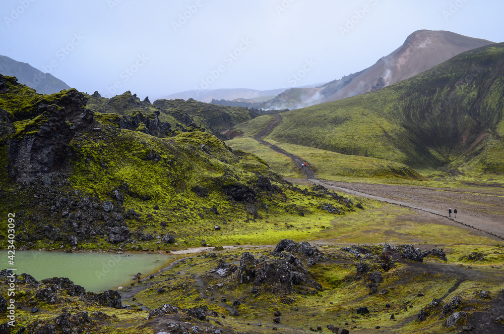 Hikers on the Laugahraun lava field hike in Lanmdannalaugar, Fjallabak Nature Reserve, Iceland Hikers on the Laugahraun lava field hike in Lanmdannalaugar, Fjallabak Nature Reserve, Iceland