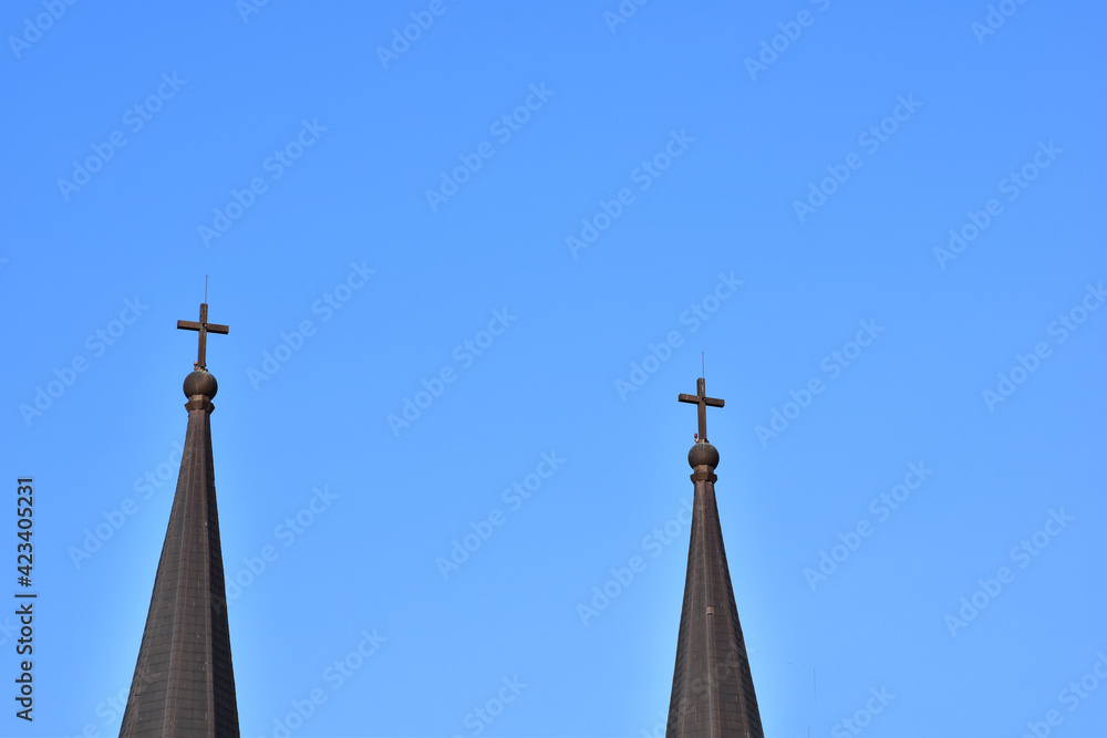 Church Roof with a cross. Church building roof with holy cross. Cloudy moody blue sky background. Minimal architecture design and detail. Exterior design and detail. Abstract architecture. Church Roof with a cross. Church building roof with holy cross. Cloudy moody blue sky background. Minimal architecture design and detail. Exterior design and detail. Abstract architecture.