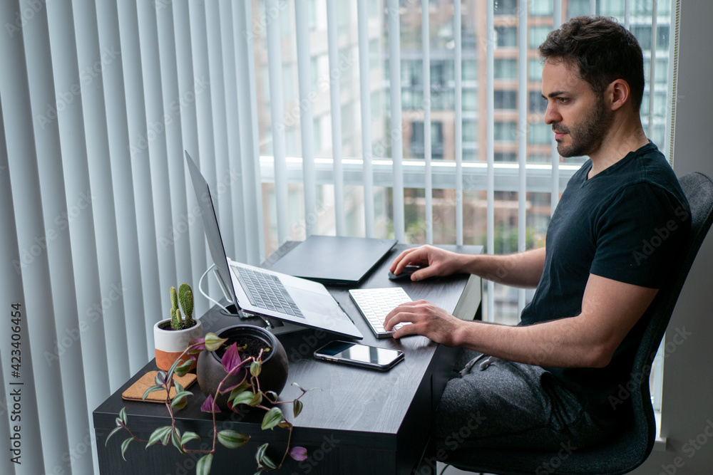 見晴らしのいい部屋で在宅ワークをする男性 Stock Photo Adobe Stock