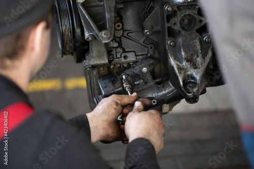 Auto mechanic checking an internal combustion engine