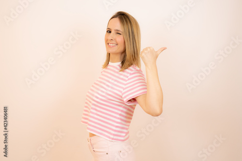 Smiling pretty young woman showing thumb up isolated over white background
