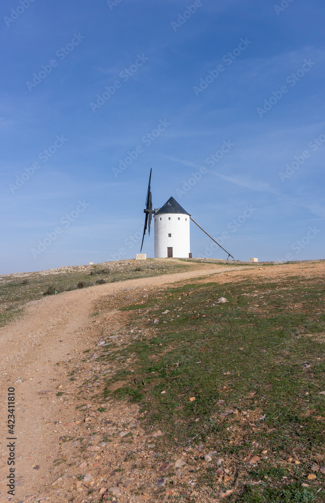 whitewashed historic windmill typical of the La Mancha region of central Spain under a blue sky