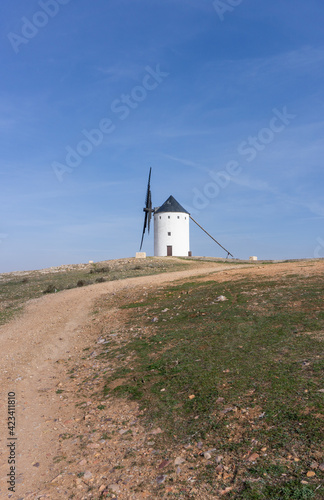 whitewashed historic windmill typical of the La Mancha region of central Spain under a blue sky