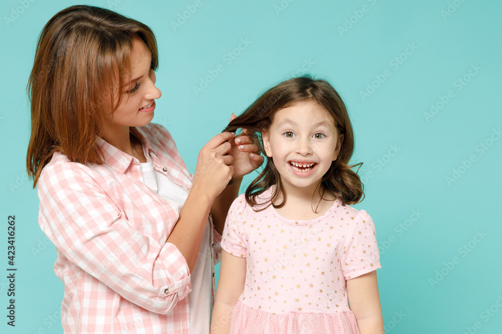 Happy woman in pink clothes have fun child baby girl 5-6 years old. Mommy play hair weave pigtails little kid daughter isolated on pastel blue azure background studio Mother's Day love family concept Happy woman in pink clothes have fun child baby girl 5-6 years old. Mommy play hair weave pigtails little kid daughter isolated on pastel blue azure background studio Mother's Day love family concept
