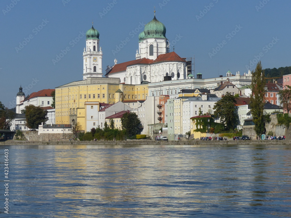 Baroque buildings of Passau cast their reflections onto the full banks of the Danube.
