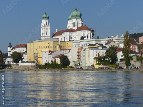 Baroque buildings of Passau cast their reflections onto the full banks of the Danube.