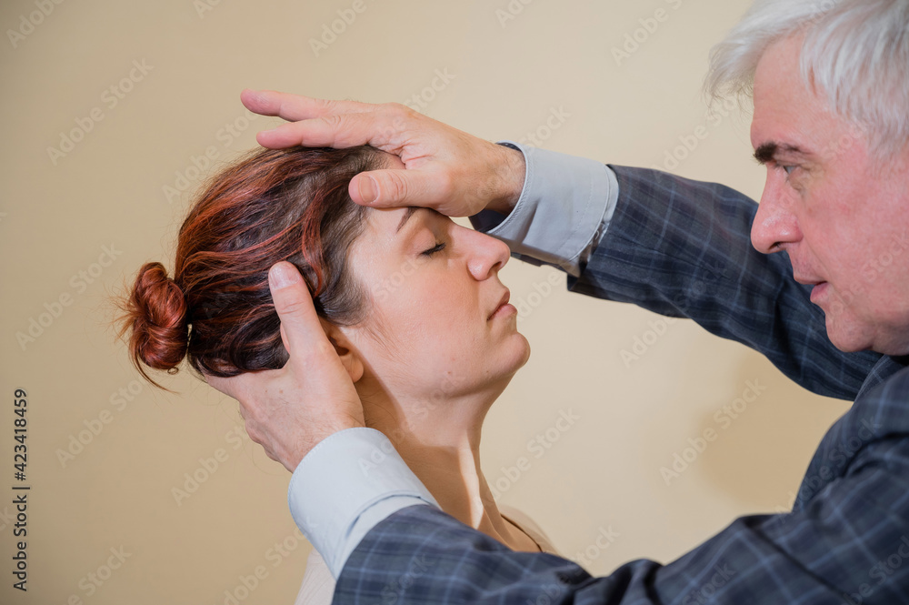 Fototapeta premium Mature gray-haired man hypnotizes Caucasian woman during hypnotherapy session. The psychologist uses alternative treatments for the subconscious mind