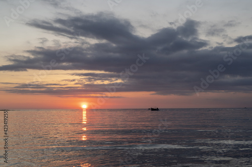 Tramonto sul mare  cielo con nuvole e riflesso dei raggi del sole sull acqua. 